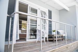 a balcony with a table and chairs on a porch at The Whale on Main B&B in Hermanus