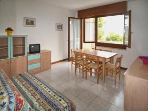 a room with a table and chairs and a bedroom at Occidente in Lignano Sabbiadoro
