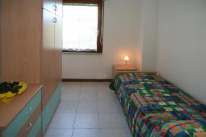 a bedroom with a bed and a desk and a window at Occidente in Lignano Sabbiadoro +32 photos