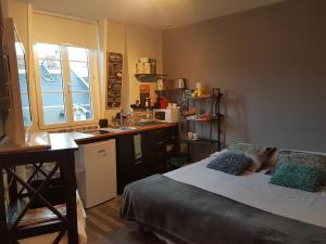 a small bedroom with a bed and a kitchen at Home St. Germain in Trouville-sur-Mer