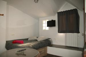 a small bedroom with a bed and a window at estudio mirador in Güéjar-Sierra