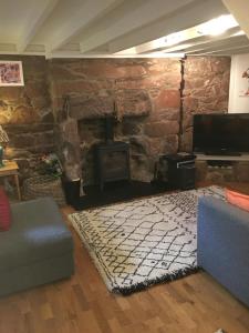 a living room with a stone fireplace and a couch at Dunnottar Cottage in Stonehaven