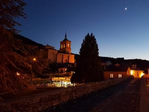 a building with a clock tower at night at Casa Blanquita in Molinaseca