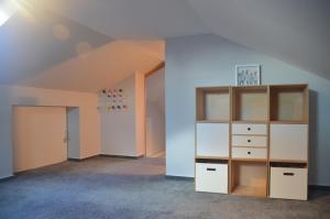 an attic room with a book shelf and a closet at Uns Landhus 43 - 5 Personen in Tating