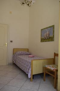 ein kleines Schlafzimmer mit einem Bett und einem Stuhl in der Unterkunft A Due Passi Dal Mare in Marina di Mancaversa