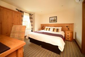 a hotel room with a bed and a desk at The Star Inn 1744 in Thrussington