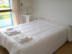 a white bed with white towels on top of it at Serra Gaúcha Uva e Vinho in Bento Gonçalves