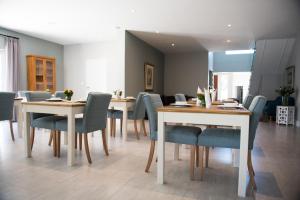 a dining room with wooden tables and blue chairs at The Whale on Main B&B in Hermanus
