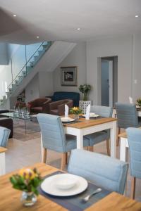 a dining room with blue chairs and a table at The Whale on Main B&B in Hermanus