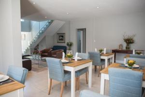 a dining room with blue chairs and tables at The Whale on Main B&B in Hermanus