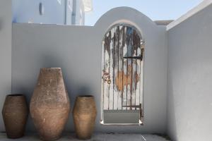 three vases sitting next to a wall with a mirror at The Whale on Main B&B in Hermanus