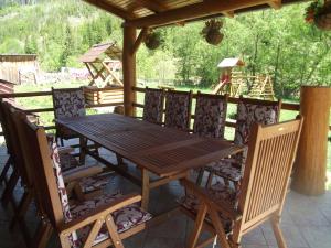 a wooden table and chairs on a patio at Cabana Piatra Runcului in Vatra Moldoviţei