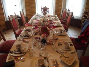 a long table with plates and glasses on it at Cabana Piatra Runcului in Vatra Moldoviţei