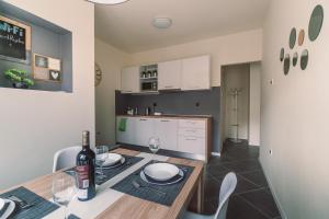 a kitchen and dining room with a table with a bottle of wine at Point Rijeka in Rijeka