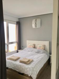 1 dormitorio con 1 cama con 2 toallas en Duplex by the Sea, en Benalmádena