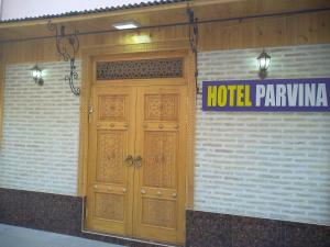 una puerta de madera en un edificio con una señal de aparcamiento del hotel en Boutique Hotel Parvina, en Bukhara