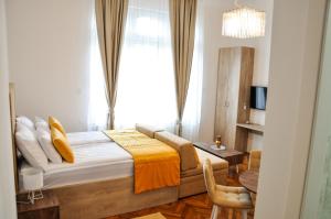 a bedroom with a bed and a table and a window at MAROON Free Parking in Sarajevo