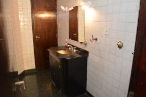 y baño con lavabo y espejo. en Hostal Bernardo Salta en Salta