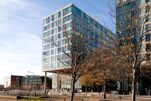 a tall glass building with trees in front of it at 2 Bedroom 2 Bathroom Apartment in Central Milton Keynes with Free Parking and Smart TV - Contractors, Relocation, Business Travellers in Milton Keynes