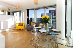 a dining room with a glass table and a yellow chair at 2 Bedroom 2 Bathroom Apartment in Central Milton Keynes with Free Parking and Smart TV - Contractors, Relocation, Business Travellers in Milton Keynes
