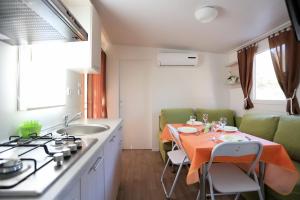 a kitchen with a table with an orange table cloth at Mobile homes-Slanica in Murter