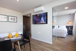 a hotel room with a bed and a table and a room at Hotel Ciudadano Suites in Montevideo