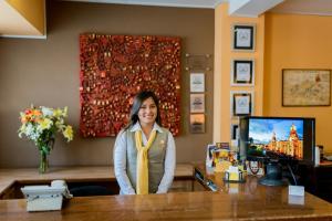 a woman sitting at a reception desk in a hotel room at Hotel Los Tambos Boutique in Arequipa