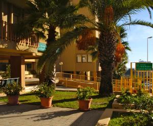 een groep palmbomen voor een gebouw bij Hotel Residence Ulivi E Palme in Cagliari