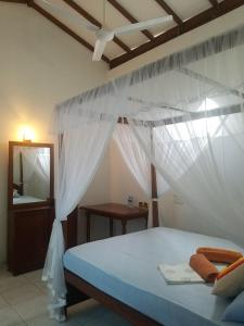 1 dormitorio con 1 cama con mosquiteras blancas en Mermaid Inn, en Mirissa