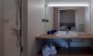 een badkamer met een wastafel en een spiegel bij La Frasera Alojamiento Rural in Vacarisas