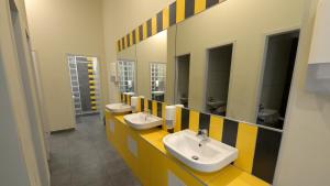 a public bathroom with two sinks and mirrors at The Hive Party Hostel Budapest in Budapest
