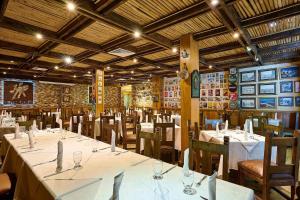 a dining room with white tables and chairs at Hotel Riazor in Santo Domingo