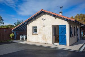 a small white building with a blue door at Maison Lous Amics in Orx
