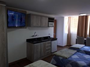 a kitchen with two beds and a sink and cabinets at 100% Flats in Gramado +94 photos