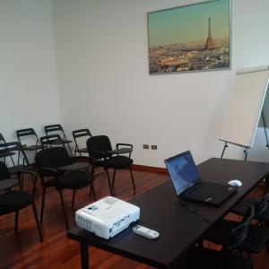 a room with a table with a laptop and chairs at Hotel Route 9 in Cadeo