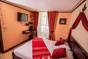 a small bedroom with a bed with red curtains at Morenica del Rosario in Cuenca