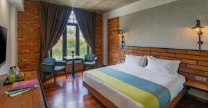 um quarto de hotel com uma cama e uma janela em Treasures Hotel and Suites em Malaca