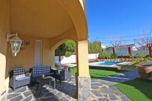 a house with a patio with chairs and a pool at House with Pool and Sea Views in Alella