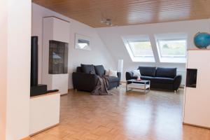 a living room with two couches and a tv at Ferienwohnung Schneckental in Pfaffenweiler