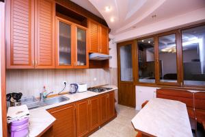 una cocina con armarios de madera y fregadero en Apartment #1 in the city center, en Ereván