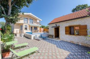 a patio with two chairs and a house at Dalmatian village charm - spacious villa with pool near Trogir in Primorski Dolac