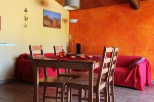 a dining room with a table and chairs and a couch at Gite Guillot - hameau calme 8km de Jonzac in Nieul-le-Virouil