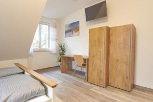 - une chambre avec un bureau, un lit et une armoire en bois dans l'établissement Zur Friedenseiche, à Aichach