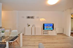 a living room with a tv and a glass table at Apartment Bonsol in Lloret de Mar