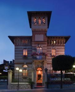 un edificio con una torre dell'orologio sopra di Cangrande Hotel a Lazise