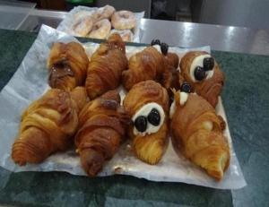 un montón de croissants con los ojos en una mesa en Bed and Breakfast Adduci's House, en Roma