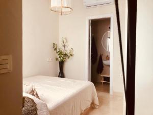 セビリアにある"Aires de Lumbreras" Duplex Terrazaの白いベッドルーム(ベッド1台、花瓶付)