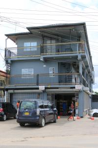 a building with a van parked in front of it at Happy Holidays Style Residences in Paramaribo