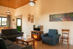 salon z kanapą, krzesłami i telewizorem w obiekcie Adonis Villa w mieście Coral Bay