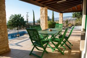 zielony stół i krzesła na patio w obiekcie Adonis Villa w mieście Coral Bay
